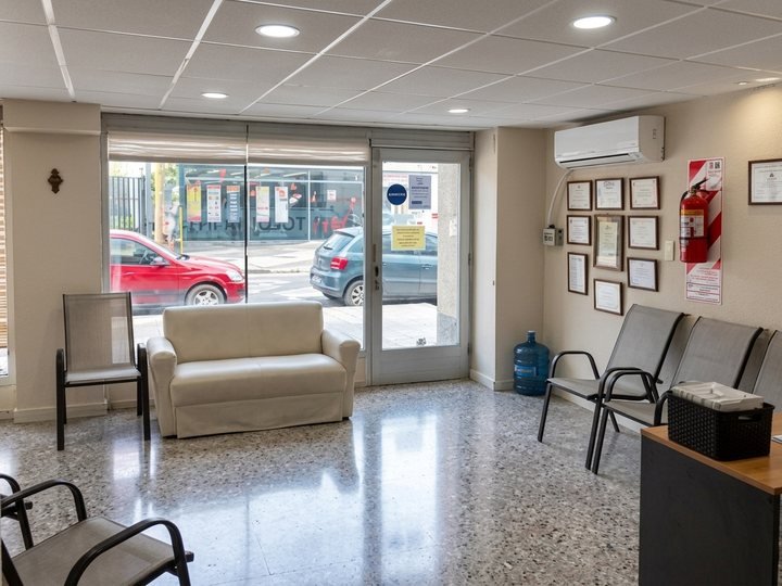 Sala de espera con sillones y vista a la calle